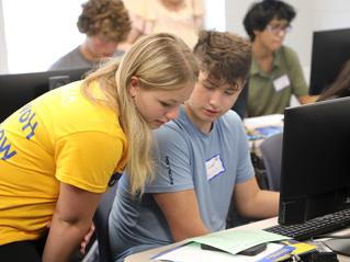 Male Student receiving assistance by Female Counselor at Computer Lab Workstation